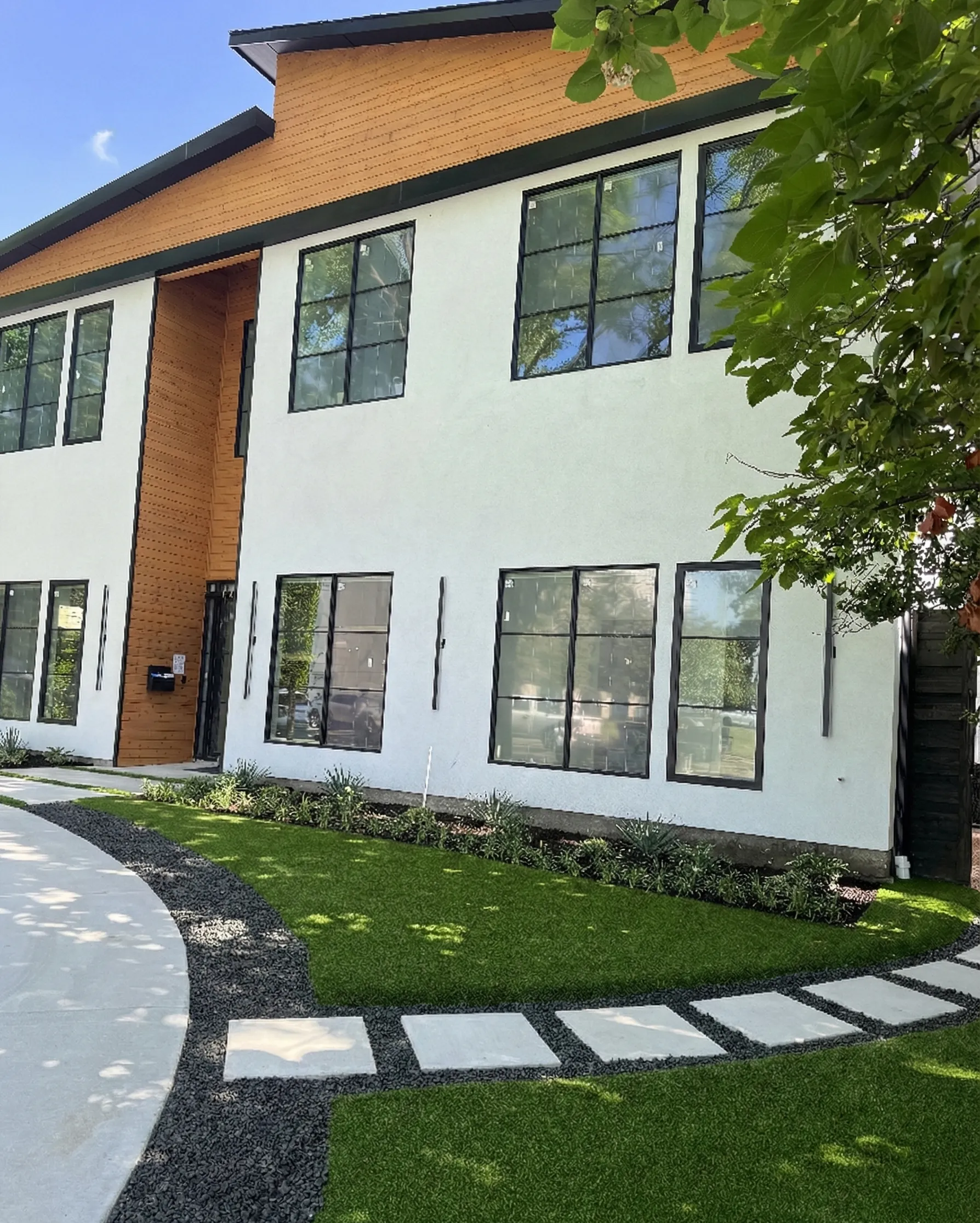 Modern luxury custom single-family home exterior with white stucco and wood accents, built by Rody Group in University Park, Dallas